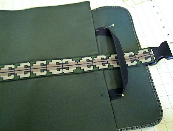 14. Find the 10" length of ¾" webbing. 15. Insert one end into each of the small openings in the flap seam you made earlier.