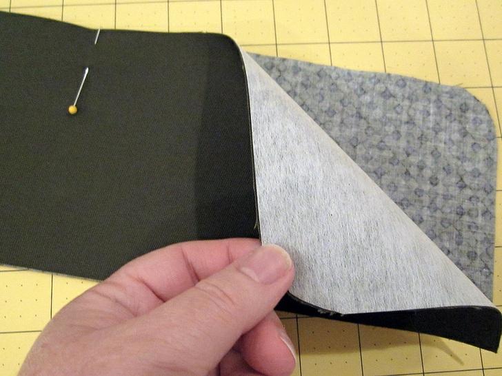2. Working on the exterior side of the flap, open out one folded side of the bias tape and align the raw edge of
