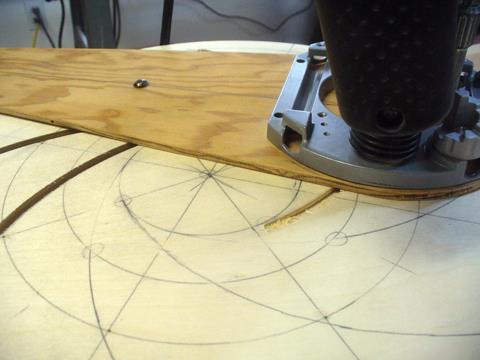 Using a plunge router with a 1/4 upcut spiral bit and a trammel base we set the pivot point the same as above when we marked it.