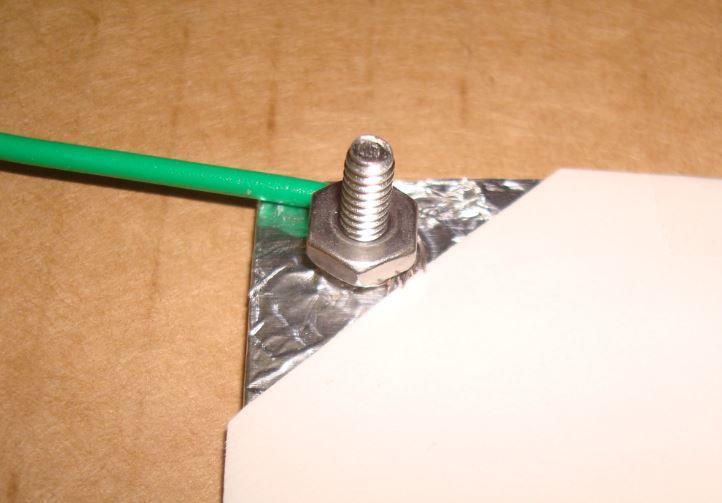 Wrap the wire end around the screw. Push it through the hole in the fixed envelopes. Tighten on the nut.
