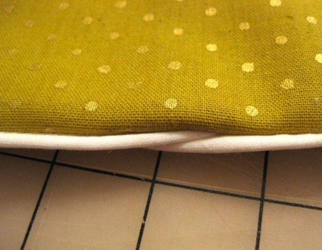 STEP 15: Turn the pillow right side out. The finished piping overlap will look like the image above. Nice and neat!