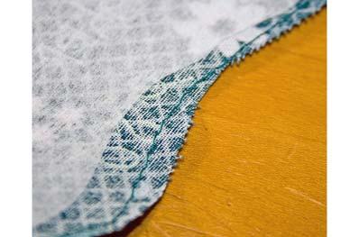 Finish the edges of the apron top pieces with a double folded hem all the way around to meet at the facings. 13a.