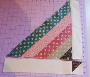 Sew the half-square triangle strip to the other side of the basket. Press towards the cream fabric to reduce bulk. Repeat to complete 9 blocks.