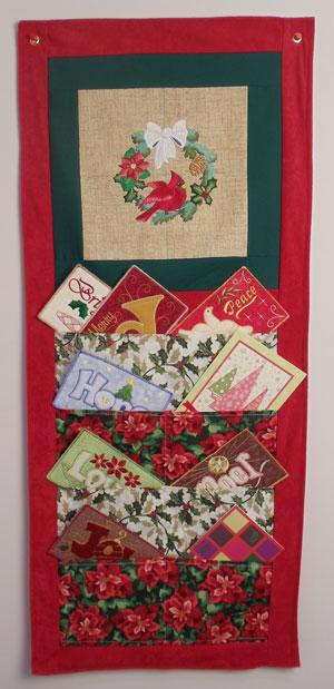 Hang your holiday wall hanging for friends and family to cherish year after year. Store Christmas cards, decorations, or other keepsakes in this lovely holiday-themed wall hanging!