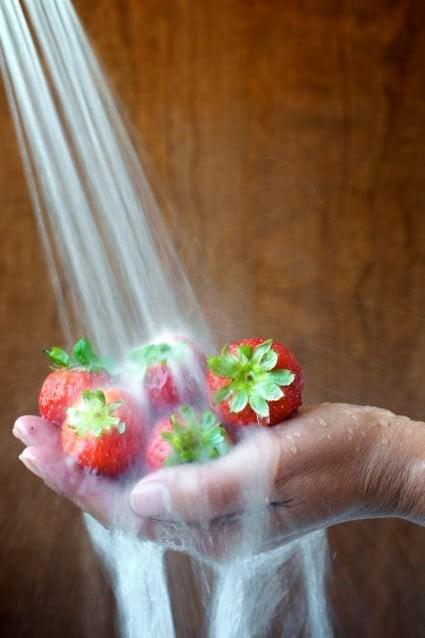 This strawberry photograph was shot at 1/8 second, which is a slow shutter speed. We wanted the water to be blurred and soft looking when it splashed on the strawberries.