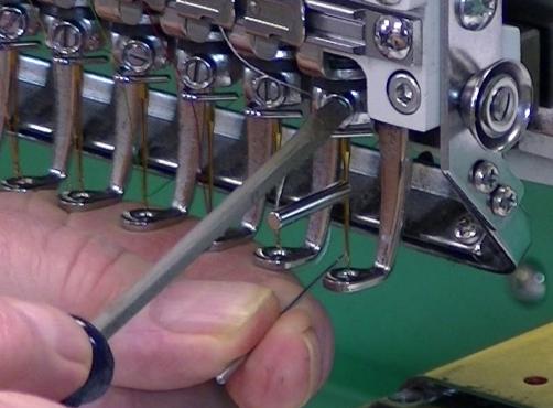 Each Needle has a groove ground or formed in it s face, a slot for the thread to ride in.