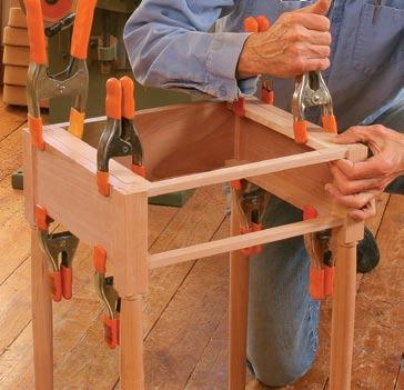 The runners and kickers are simply glued and clamped into place (above), flush with the top and bottom of the aprons and rails.