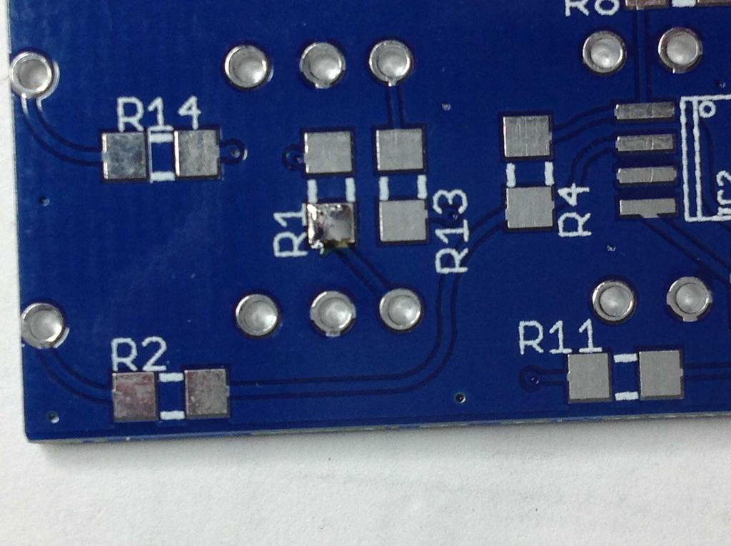Pick up one of the resistors using the tweezers, & place the ends of the resistor centrally over the two pads. Notice how much clearance you have around the outside of the resistor on the pads.