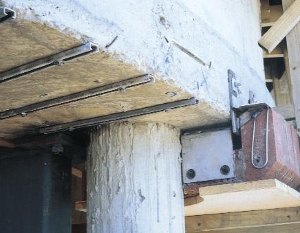 The system consists of double-headed studs welded to flat rails, positioned around the column.
