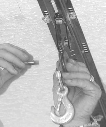 Temporarily remove the pulley at the end of the spacer channel pulley bar (D) (use pliers to remove the cotter pin then remove the clevis pin to release the pulley) (SEE