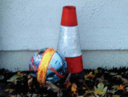 photograph of a football in contact with a traffic cone is shown across.