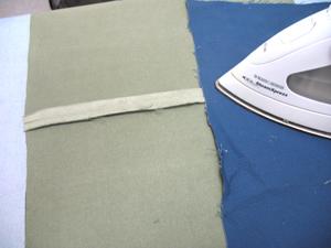 the short ends. Sew a 1/2 inch seam on the pinned end only. Then, lay the fabric flat and press the back seam.
