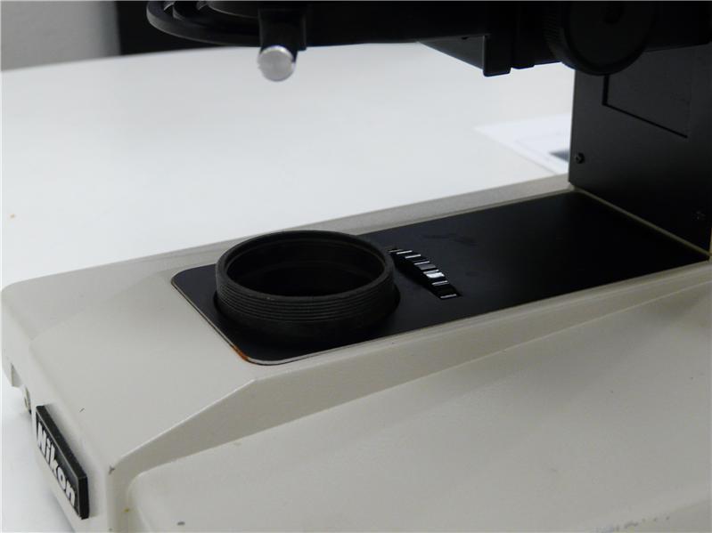 STEP : Remove the lens housing from the base of the microscope by unscrewing the cap that holds it in place.