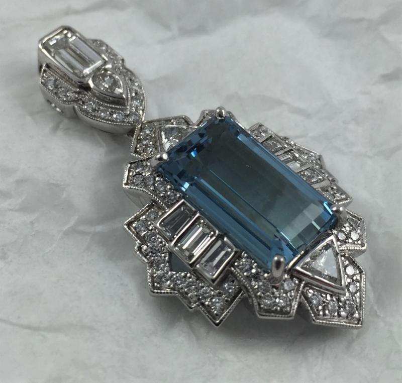 We worked with our best hand carver to make this unique pendant with blue Aquamarine and an assortment of colorless diamonds.