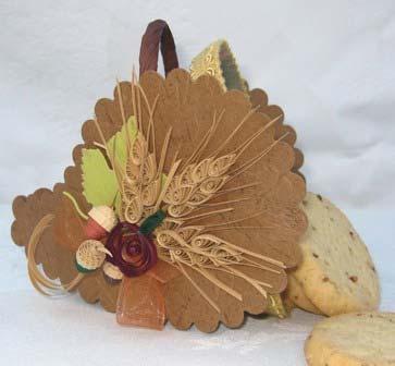 The rust organza ribbon with an acorn accent finished off the wreath. Cornucopia Treat Basket: While the brown paper in the kit was used for the leaves in the wreath I also saw it as a cornucopia.