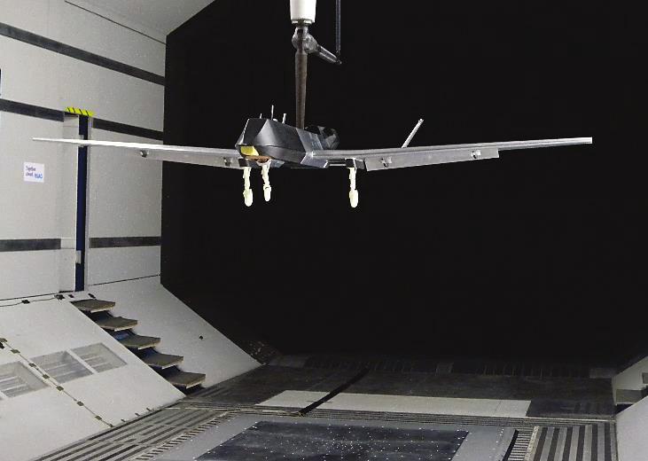 (a) (b) Figure 2: UAV model mounted in the WT test section. The microphone array is also visible on the floor.