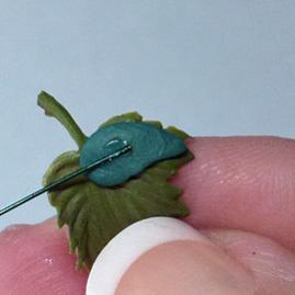 Dip the tip of the wire into super glue, and lay the tip of the wire into the clay while it s still on the leaf.