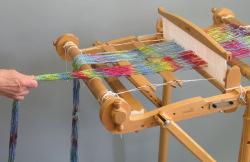 After you have all the threads through the heddle slots, make sure that the apron rod and warp beam are secured.