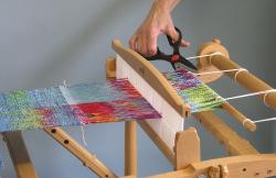 When you remove the warp from the loom do not cut the warp at the fabric line. But do cut the warp threads as close to the apron rod as you can. Remember you need the loom waste for fringe.
