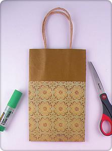 3. Cut a piece of the metallic sheer ribbon the entire width of the front of the gift bag. 4.