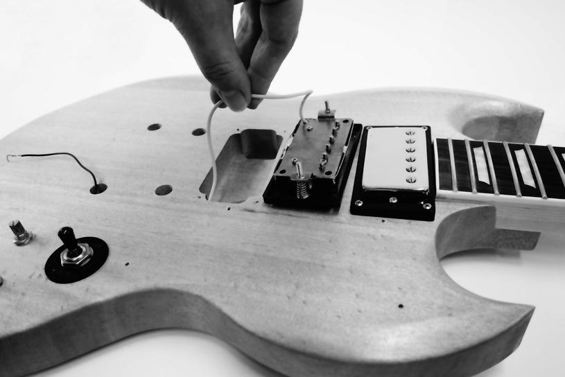 the guitar. Insert the somewhat taller bridge pickup into the opening closer to the bridge.