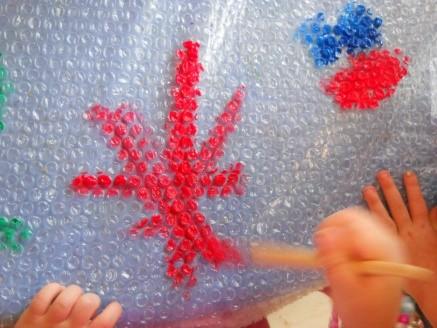 teacher tapes the large sheet of bubble wrap to the table if using a