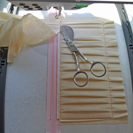 Trim the excess fabric from above the top stitch line, being careful not to trim the batting