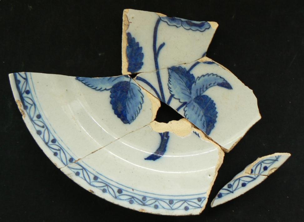 their interior with a common stylized 18 th century Dutch design. The fragments of both backs are covered in a typical white pitted glaze.