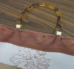 Add the handles to the purse by placing the loops in between the layers on the ends.