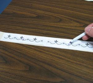 Trim around them to make them more manageable for marking. Place the templates on one of the canvas strips.