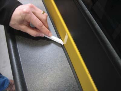 Slide the tool along the edge trim while pressing it in toward the vehicle surface.