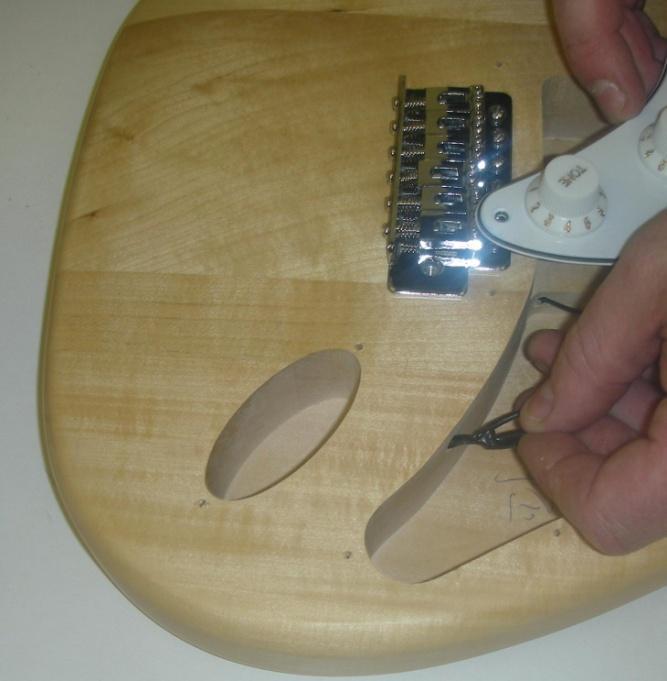 The pickups and controls are pre-assembled onto the pick-guard and simply need connecting to the output jack socket