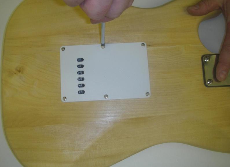 Secure the pick-guard with the small dome-head screws provided into the predrilled pilot holes.
