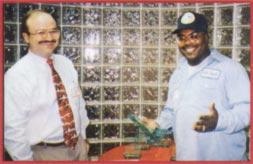 David Shellman (right), a Baker Drywall employee for 1O years, receives the Unsung Hero Award from Steve Baker at the company s 1995 Awards Ceremony.
