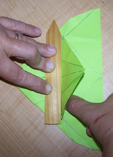 The best way to get a good initial crease with a straight edge is to lift the piece to be folded up 90 degrees along the straight edge and use the back of your finger nail to rub up the crease along