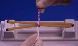 purple strand through the white loop. Regrasp purple strand with right hand.