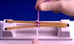 again pass purple strand through forming a double loop.