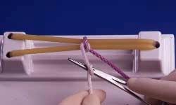 White strand is drawn toward operator with left hand and looped around needleholder held