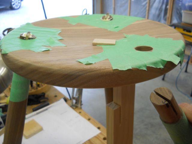 Gluing leg tenons into seat and locking with tapered wood wedges: The tenons and wedges are carefully brought down close to the seat surface with a 150 grit sanding disk in a 4 right angle grinder.