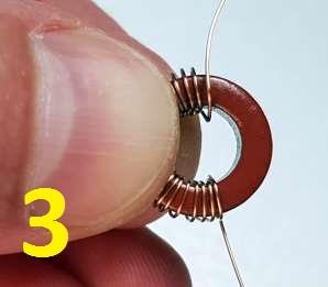 Step by step: 1) Hold the toroid between thumb and finger, and thread the first turn of the wire through from top to bottom.