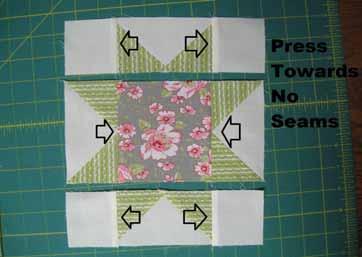 Press the seam allowances in the top and bottom row outwards towards the small cream squares and the seam