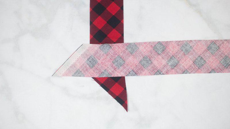 Lay the bias tape at a right angle with the right sides facing each