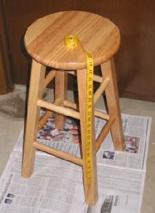Measure the height, width, and depth of your stool. Then find a box that will fit over it without touching the top or sides of the stool.