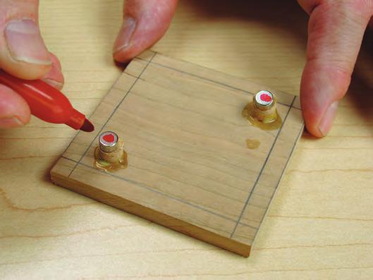 Use dowel centers to mark magnet holes on the underside of the lid. Align the base to the lines drawn on the lid, and press down to make the marks. Determine the base magnets orientation.