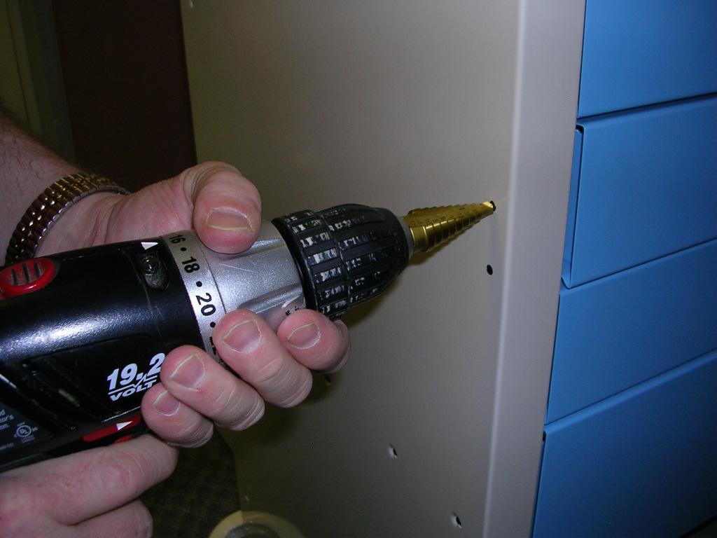 Using a step drill bit or a 9/16-in. drill bit, drill four 9/16-in.