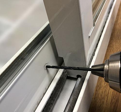Drill a 1/4-inch hole in your stationary sliding glass door frame for the bolt.