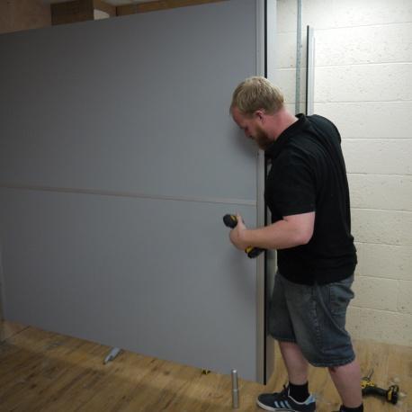 Then using the supplied zinc screws attach the wall channel to the upper partition panel.