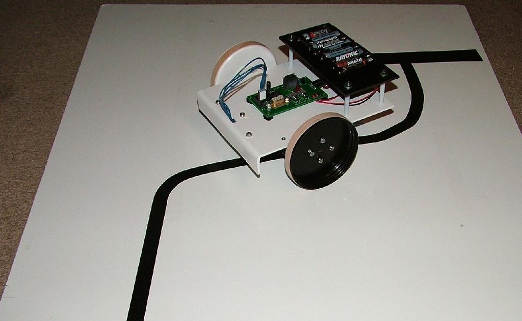 Line Following Board Figure 20. A CheapBot robot on a line follower board. The board is a sheet of melamine and the black lines are electrician s tape.