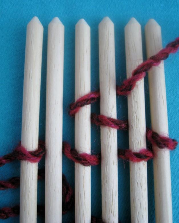 Weaving from left to right, pass the weft yarn under stick 2, over stick 3, under stick 4, over stick 5, under stick 6. (photo 5) Sticks Photo 5 1 2 3 4 5 6 Do not pull the weft yarn too tight.