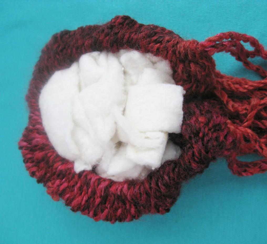 Stuff the Bauble and Tie the Bottom Ends Together Turn the bauble over. Fill the cavity with bits of stuffing, such as quilt or cushion batting, old nylon stockings, fabric scraps, etc.